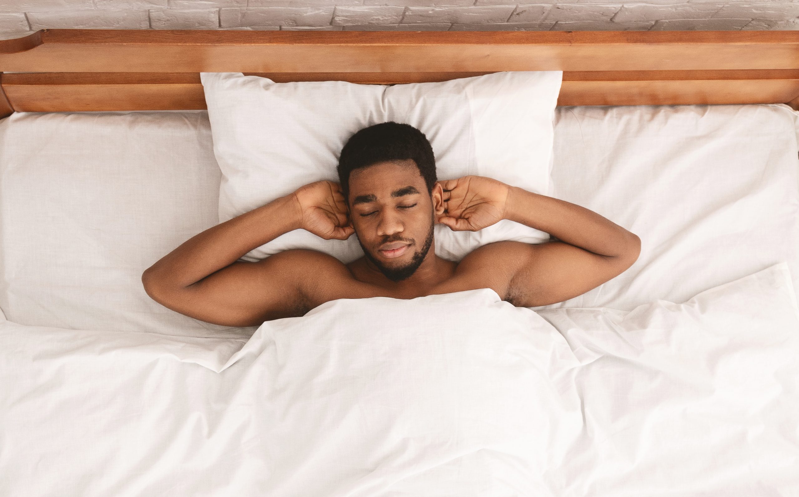 Relaxed black guy lying with hands behind head