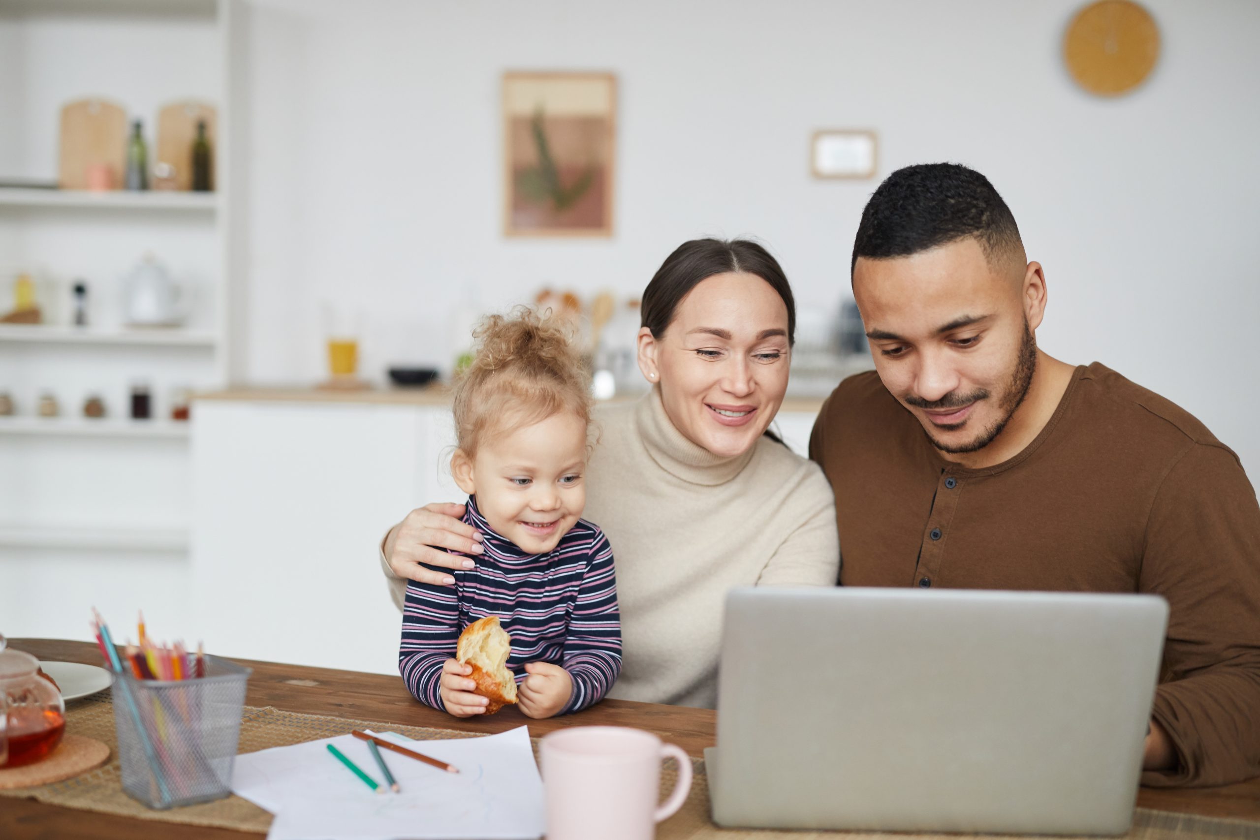 Happy Mixed-Race Family Using Laptop at Home